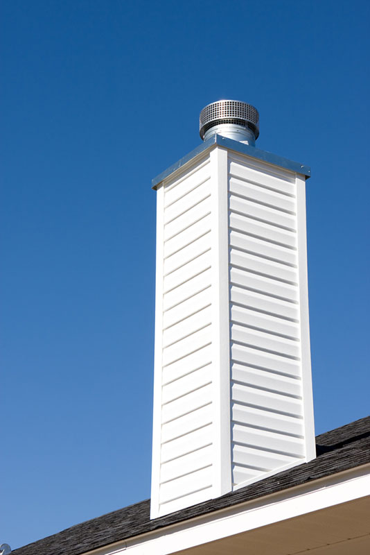 Stock photo of a white chimney with a cap