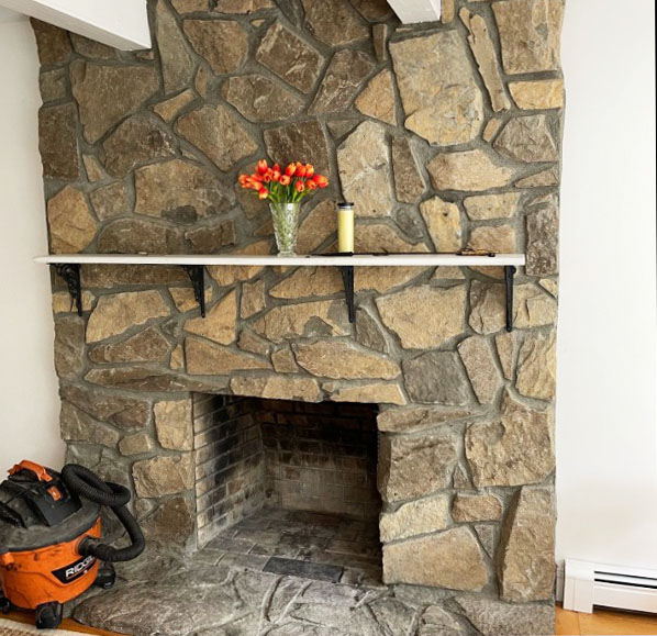 Brown rock fireplace with white mantelpiece