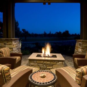 square fire pit surrounded by chairs on a patio