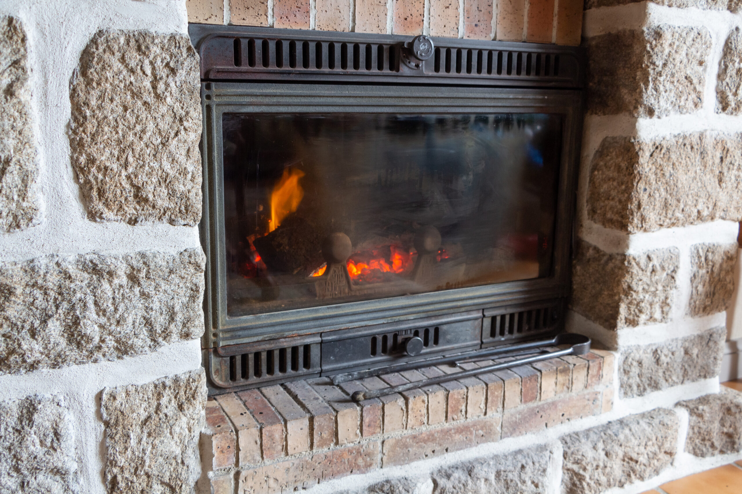Fireplace insert with a fire in a living room.