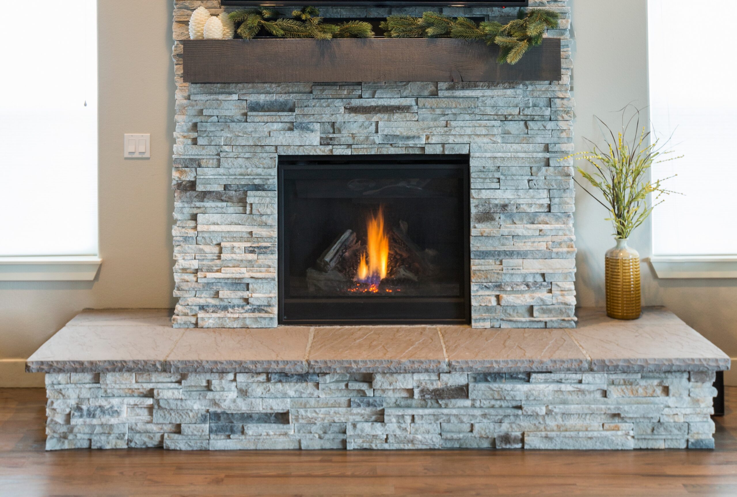 Adobe Stock image of a gas fireplcae insert with a stone fireplace.