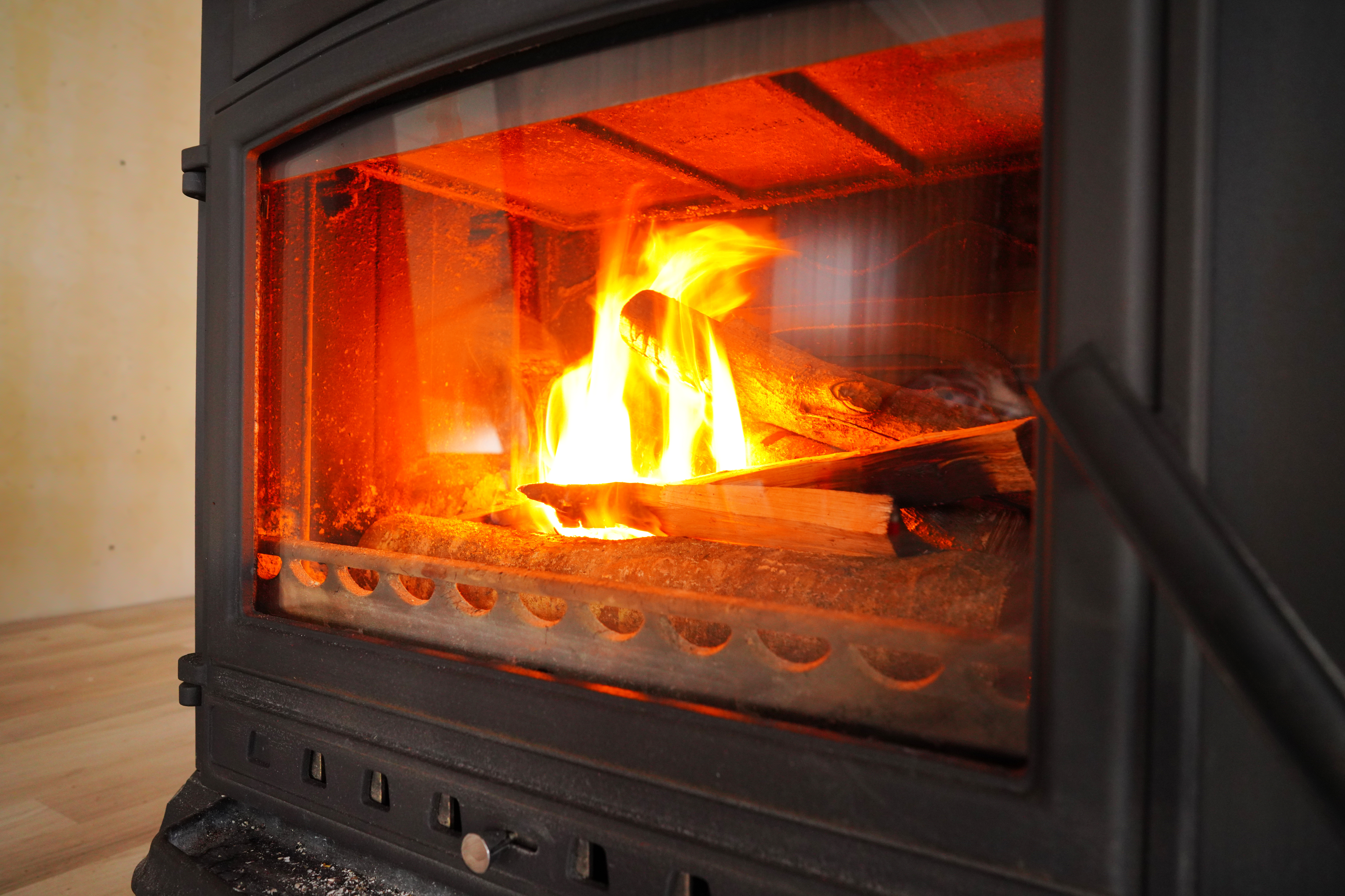 Adobe stock image of wood burning in a cast iron wood stove.